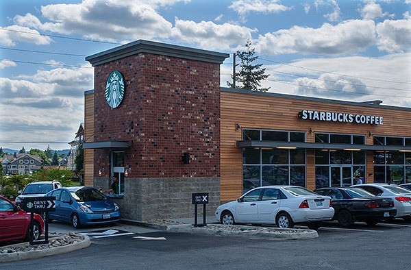 A Starbucks employee hands a drink to a drive-thru customer at the new Silverdale store Aug. 6.