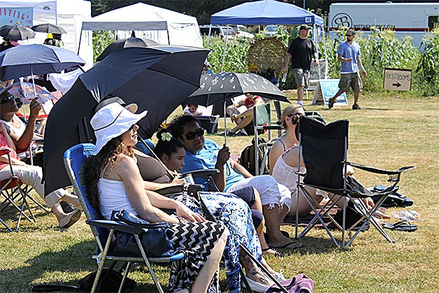 Farm Funk 2016 festival attendees sit in front of the stage listening to one of the three youth performances. Many people brought umbrellas to provide shade in an effort to cool off; the temperature in the middle of the Aug. 20 festival was about 90 degrees.