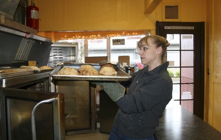The Daily Dish owner Lynn Beckwith pulls freshly-baked pasties from the oven Monday morning in preparation for the lunch crowd.