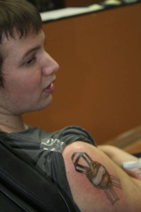 Chris Bossom watches tattoo artist ErinAshleigh Wehmeyer as he receives a tattoo Thursday in honor of the four Lakewood police officers slain in November.