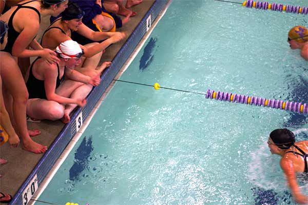 Kingston sophomore Britannia James (white cap) cheers on a fellow swimmer Tuesday afternoon in the North Kitsap Community Pool.