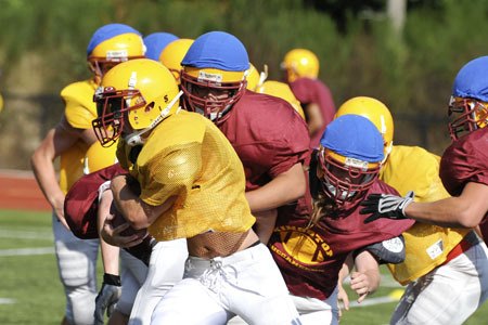 Kingston High School football player Nick Zehrung powers through the defense during practice at the KHS fields Tuesday. Kingston and North Kitsap open their 2009 seasons tonight.