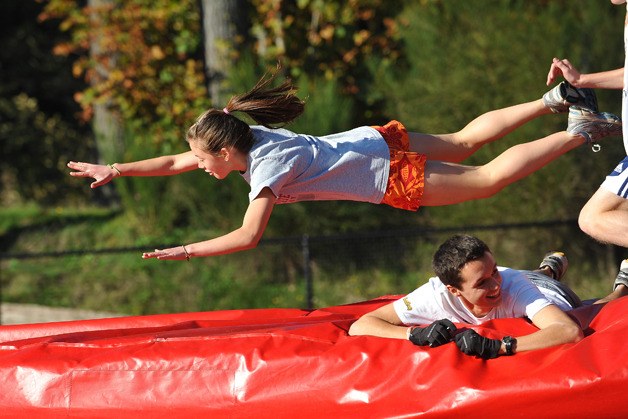 Junior captain Marina Roberts dives over another cross country runner during practice on Oct. 20. The teams were training using the “fireman drill.” Typically the drill does not involve a high jump pit