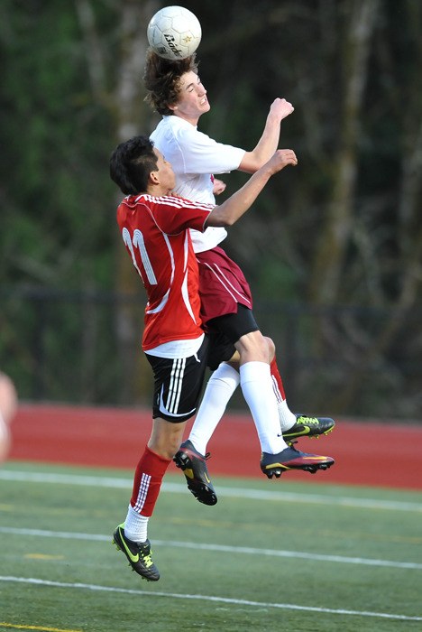 Kingston High's Chad Trask heads the ball over Port Townsend's Sebastian Lyons Tuesday at Kingston's Buccaneer Field.