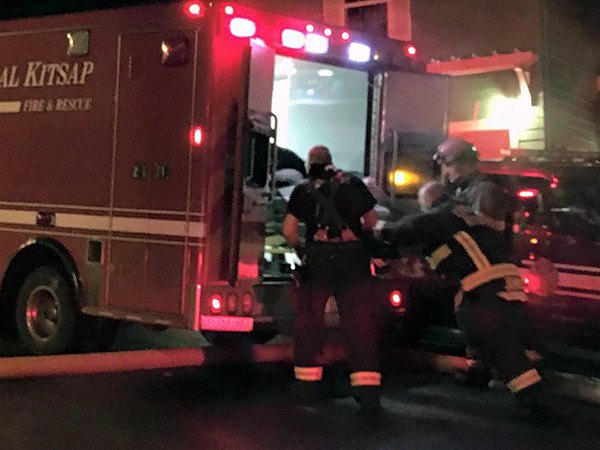 Firefighters load an injured crew member into the back of a medic unit for transport to Harrison Medical Center in Bremerton