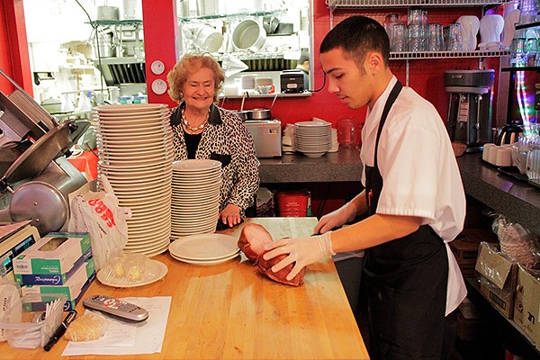 Betty Walker watches as employee Michael Lawver slices turkey in her family-operated restaurant which opened this fall in downtown Bremerton. They serve three meals a day.