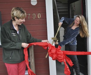 Port Gamble town manager Shana Smith and Tame the Beast Aromas  owner Haisly Jimenez share a laugh as they cut the ceremonial ribbon for the new store.