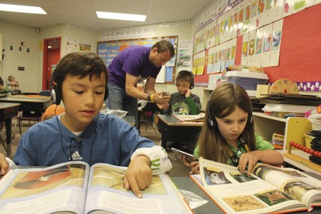 First-grade teacher Matt Taran at Crownhill Elementary School helps Michael Chichester set up his iPod while Marcelo Aguilera and Saidee Dervaes use the iPods to record themselves reading June 10.