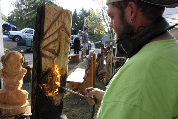 Mike Martinson of Ocean Shores slightly charrs the wood of his Tiki carving. At Old Mill Days