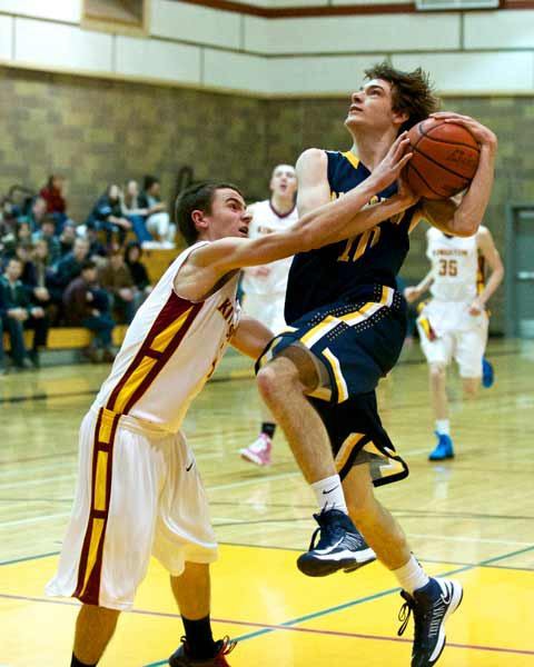 Kingston's Connor Wall attempts to stop a drive by Bainbridge's Casey Brink Dec. 27 in the Kingston High School Gymnasium.  Kingston lost 67-66 in the last minute of the game.