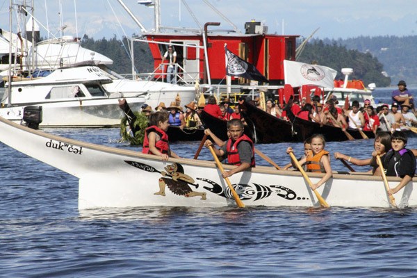 A Suquamish youth canoe returns to shore after welcoming canoes arriving from other areas