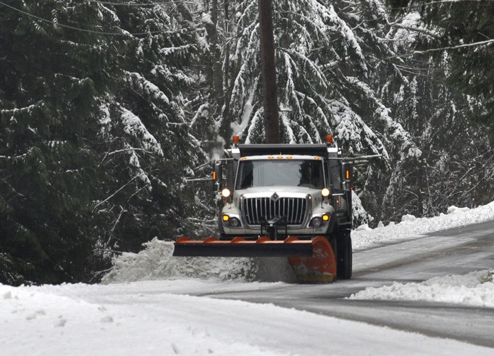 A Kitsap County plow scrapes days of hardpack snow from the northbound lane of Kitsap Lake   Road NS Friday afternoon. The county also laid down 150