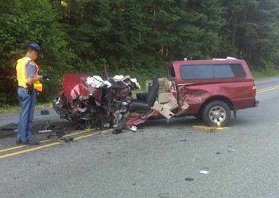 Troopers inspect the wreckage of the Ford Ranger that ran into a garbage truck Tuesday morning.