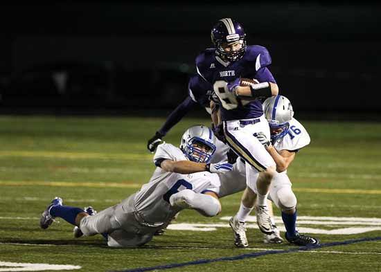 The North Kitsap Vikings challenged the Olympic HIgh School Trojans Friday at North Kitsap Stadium for their homecoming game. Vikings Wide receiver and homecoming king Andrew Urquhart makes a run through the Olympic line Friday.