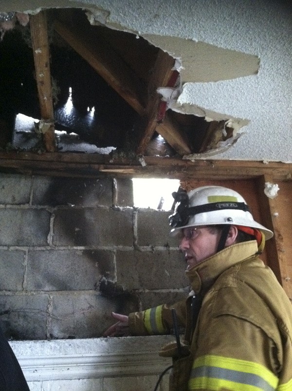 NKF&R Assistant Chief Wayne Kier explains how a fire spread from a fireplace chimney to char about 30 SF of a Suquamish rental home’s wall and roof on Saturday morning.