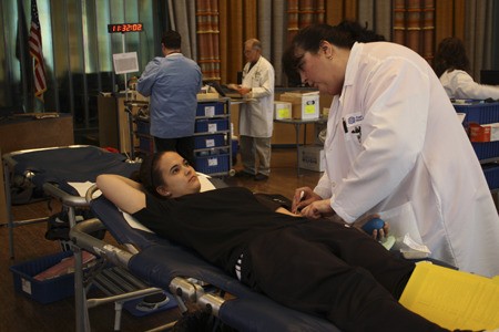 Dawn Talley gets Jen Hadaway of Bremerton ready to donate blood at a blood drive at the Norm Dicks Government Center Monday. Puget Sound Blood Center has more than 100 mobile blood drives in Western Washington a week.