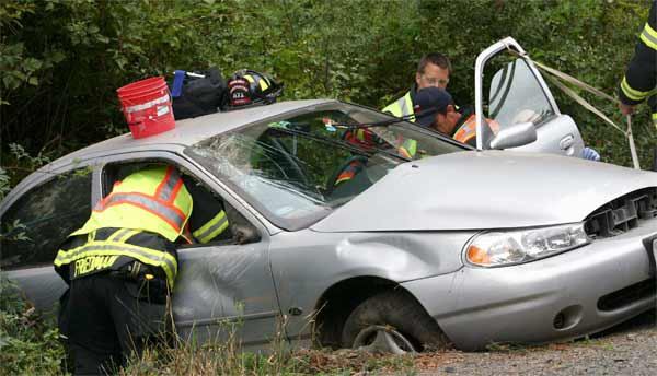 An emergency response crew from the Poulsbo Fire Department work to remove the driver of a vehicle which crashed Wednesday morning on Stottlemeyer Road.