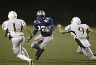 Olympic's Larry Dixon cuts between two Timberline defenders during Oly's 34-20 loss Friday at Silverdale Stadium. Dixon gained 225 yards rushing on 27 carries.