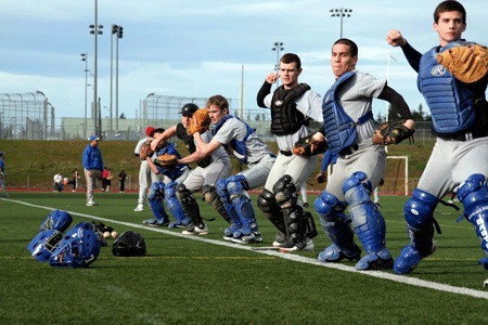 Olympic High School catchers work on their stance during a workout at the team’s second day of practice Tuesday.