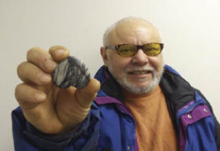 Allen Kuckuck of Poulsbo is shown here with the rock he believes bears the image of Jesus on the cross. He purchased the novelty rock as a Christmas gift at a local variety store.