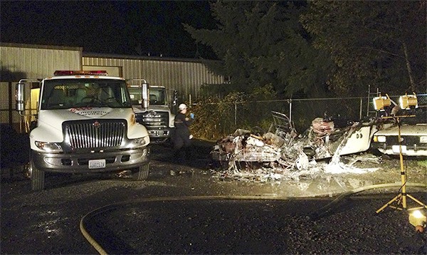 An investigator from the Kitsap County Fire Marshal's Office photographs the aftermath of an RV fire in the Kitsap Towing impound lot Aug. 16.