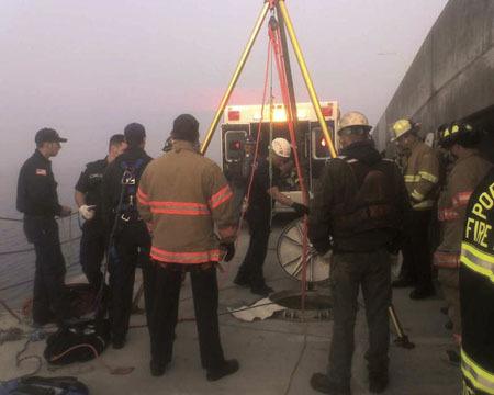 Rescue crews use a tripod extract a worker who fell 15 feet into a manhole on Hood Canal Bridge Wednesday.