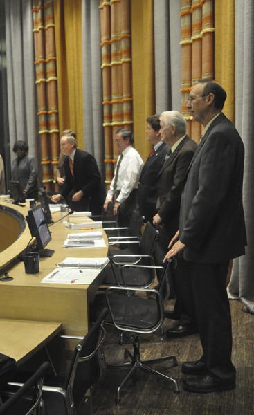 Members of Bremerton’s nine-member City Council stand while Wednesday night’s meeting is called to order.