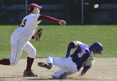 Kingston High shortstop Rico LeMay throws the ball as Sequim’s Alex Gillis slides into second.