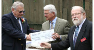 Bremer Trust trustee Mike Connolly (left) presents a $500