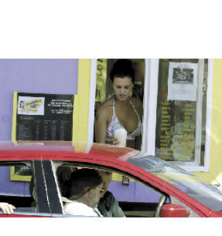 Brooke Martin hands out an espresso drink to a customer at Chicagoland Barista’s Coffee located on Naval Avenue in Bremerton. The stand recently came under fire by Bremerton’s Department of Community Development because the girls were wearing pasties on their chests.