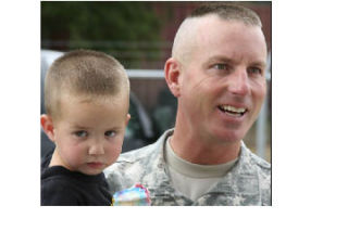 Infantry Platoon Leader Lt. Don Arnold holds his son following Tuesday’s send-off ceremony at the National Guard Readiness Center in Bremerton.