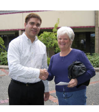 Bremerton Patriot/Central Kitsap Reporter Publisher Rob White presents Judy Duchemin of Bremerton with a $1