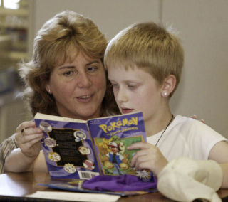 Kyle Morrill reads his Poke’mon book to his fourth grade teacher Kim Lefler during silent reading on the first day of school at East Port Orchard Elementary. Students at all South Kitsap schools headed back to class on Wednesday for the 2008-009 school year.