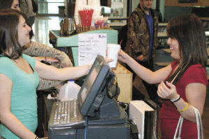 Klahowya Secondary School senior Renee Girard (left) hands senior Talisha Affonce a drink from Klahowya’s espresso stand Thursday morning.