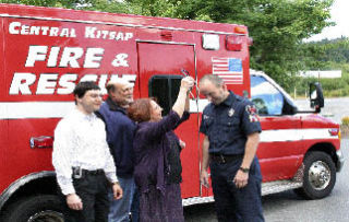 Helen Butler of Central Kitsap Medic One Foundation presents Central Kitsap Fire & Rescue firefighter/paramedic Luke Bugg with an advanced stethoscope in 2006 as board members Dr. Mark Eisenberg (left) and R.E. “Dick” West look on. Butler