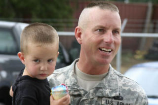 Infantry Platoon Leader Lt. Don Arnold holds his son following Tuesday’s send-off ceremony at the National Guard Readiness Center in Bremerton.