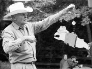 Auctioneer Tex Lewis holds up an appropriately Texas-adorned salmon during a past salmon auction to benefit the Clear Creek Task Force.