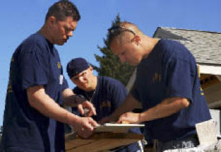 Volunteers assigned to Naval Base Kitsap measure wooden siding for a house during a Habitat for Humanity volunteer project Sept. 13.