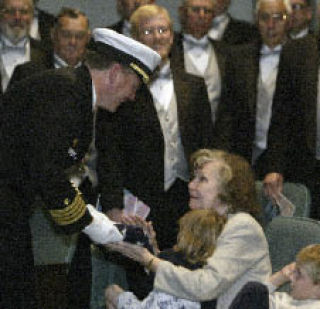 Naval Undersea Warfare Center Division Keyport retiring Capt. Jonathan Dowell presents a flag that was flown over Gettysburg to his mother Virginia Trainor