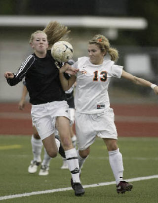 Hannah Anderson (13) muscles South Kitsap’s Crystal Polen Thursday. The Cougars and Wolves played to a 1-1 tie.