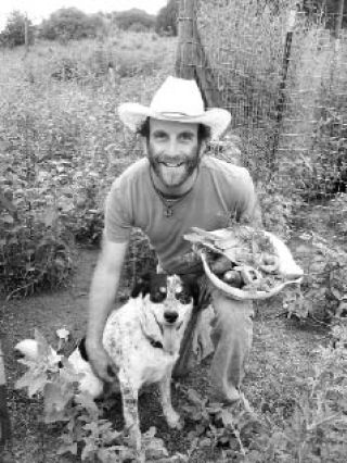 Doug Fine and his dog Sadie at the garden at Funky Butte Ranch in New Mexico.