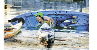 Olympic Outdoor Center owner John Kuntz rolls over in the second leg of the 15th annual Dock (Boy) Olympics Friday at the Poulsbo Waterfront. Employees participated in a four-course event testing water  skills.