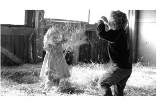 Laurel Williams and Ian Whitney throw hay with childish glee at Sunrise Hill Farm.