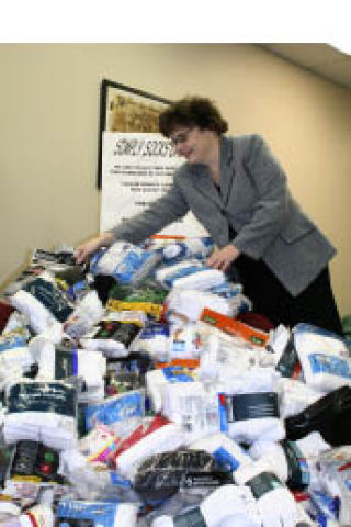 Silverdale Kiwanian Angela Sell piles the socks that were collected by Kiwanis clubs throughout Kitsap County. The socks more than 4