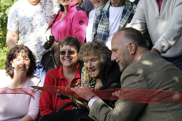 Kitsap County Commissioner Rob Gelder and Millie Muller cut the ceremonial ribbon during the dedication of Millie’s Trail June 11.