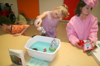 Fourth-grader Star Carlson collects her fairy figurines after presenting the book “Fairy Realm” for Orchard Heights Elementary School’s wax museum last week. At right is Makenzi Baker as Wilbur from “Charlotte’s Web.”