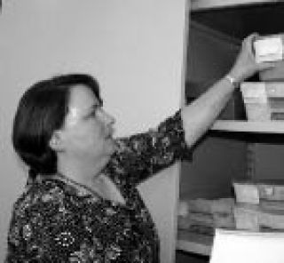 Kitsap County Elections Supervisor Dolores Gilmore pulls one of the    38 boxes of ballots that arrived last Monday off the shelf.