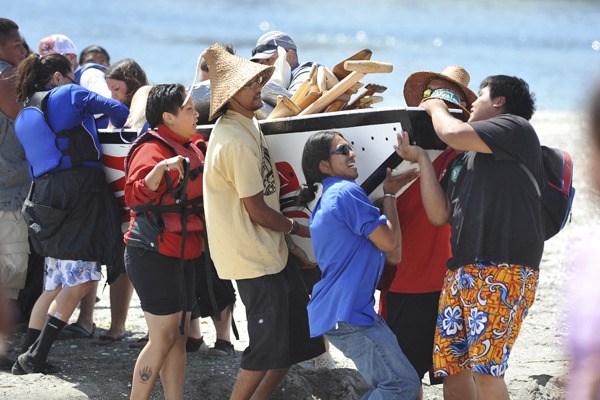 Many hands make light work: Carrying a canoe ashore at Point Julia during the 2010 Canoe Journey/Paddle to Makah.