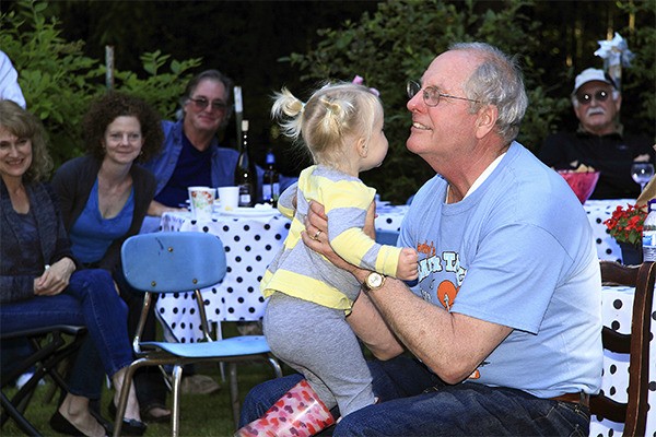 Clary Carlsen visits with his granddaughter during a retirement party last week. Carlsen retires after teaching 35 years in the North Kitsap School District.