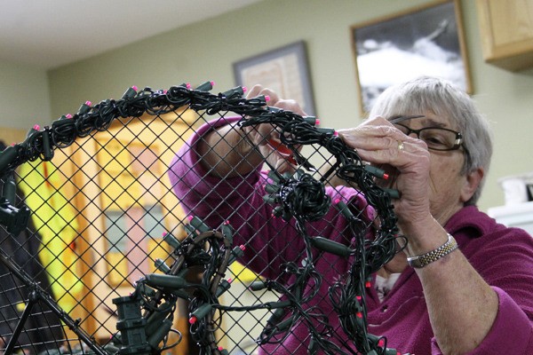 Chicquita Smith weaves lights into the frame of a seahorse Nov. 16 in the Port of Kingston office. The seahorse will be one of many new and larger lighting displays this year at the Kingston Country Christmas.